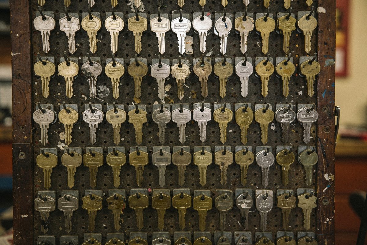 A pegboard wall hung with rows of organized brass and nickel key blanks